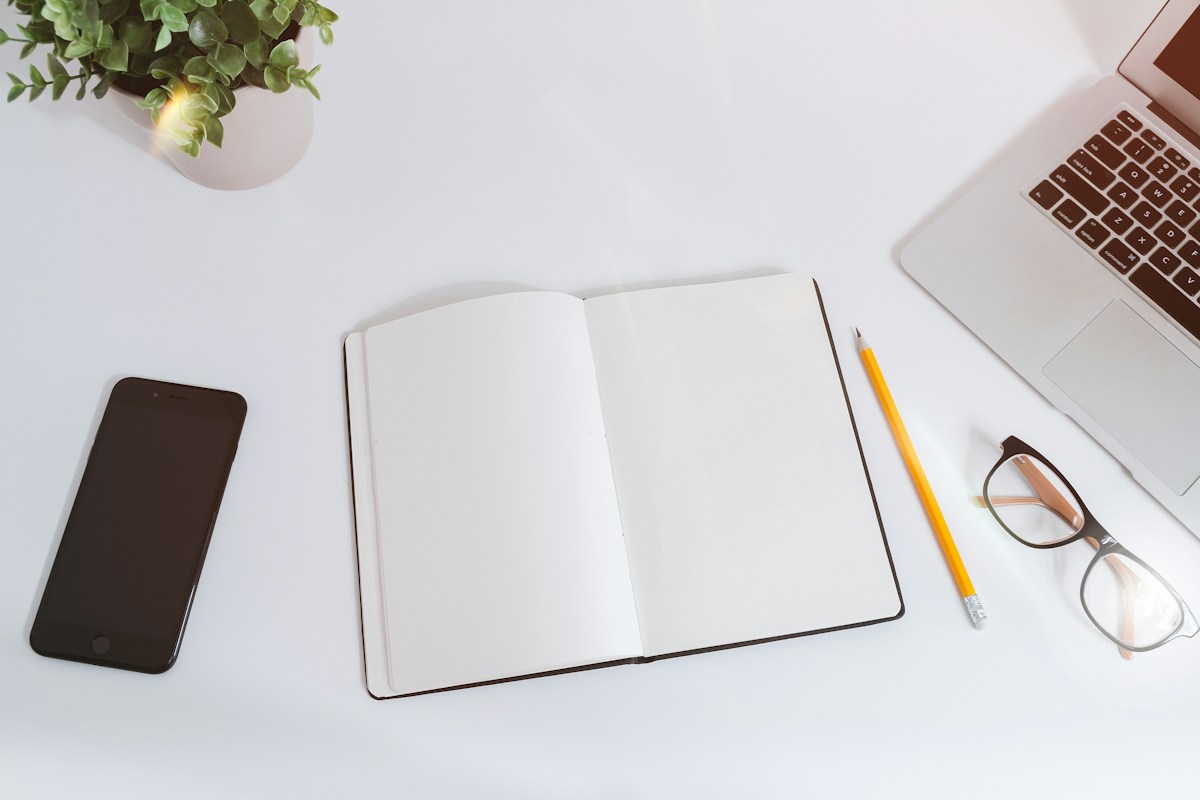 Carnet de travail et ordinateur pour préparer une stratégie digitale